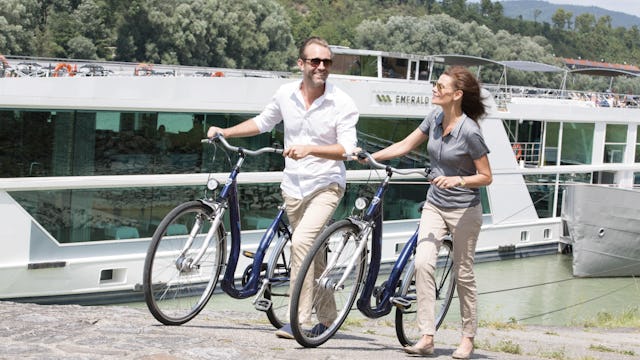 Pariskunta polkupyörien kanssa Emeraldin jokilaivan edessä.
